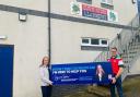 Virginia Crosbie MP presents an advertising board to Llangefni Rugby Club chairman Simon Morgan