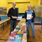 Councillor Paul Rowlinson helps local councillor, Berwyn Parry Jones distribute free books in Cynllun Bwyd Llanrug food scheme
