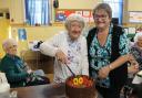 Rene Parry cuts into her 100th birthday cake with club chairperson Jackie Lewis-Davies.