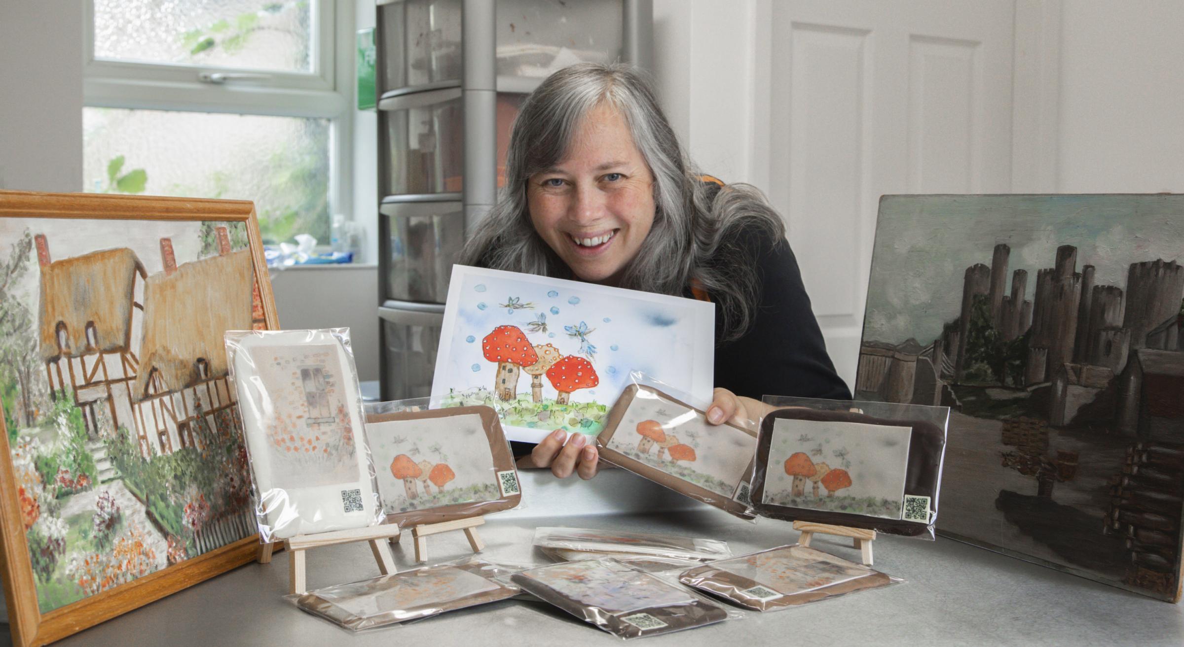 Chocolatier Jo Edwards with her late grandmothers artwork created onto chocolate bars.