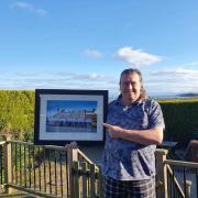 Steve Fox was presented with a framed photograph of the crew gathered before one of the station's lifeboats.