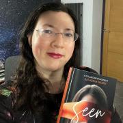 Jen Griffiths holding her personal copy of 'Seen'