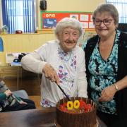 Rene Parry cuts into her 100th birthday cake with club chairperson Jackie Lewis-Davies.
