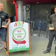 Antur Waunfawr apprentices Tom Workman (left) and Jack Williams at Beics Antur Bikes with the three awards.