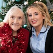 Clinical Care Practitioner Erin Jones having festive fun with resident Eve Flint, 87, at Pendine Park’s Bryn Seiont Newydd care home in Caernarfon.