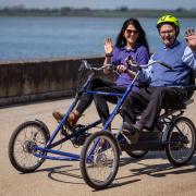 96 year old Richard Jones cycling along Caernarfon Harbour with Elliw Owen-Jones, enrichment co-ordinator.