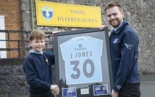 Ysgol Dyffryn Ogwen pupil Noha Wyn Jones receives the framed Wrexham AFC  shirt from Dafydd Jones from IWT. Picture Mandy Jones